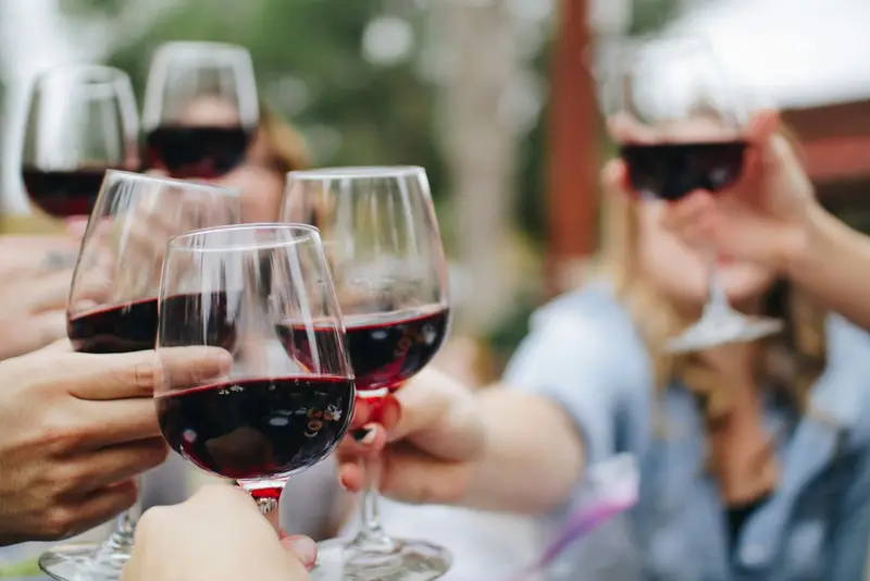 Several glasses of red wine raised together